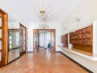 a hallway with a chandelier and bookshelves at Apartment La Floride Promenade des Anglais by Interhome in Nice