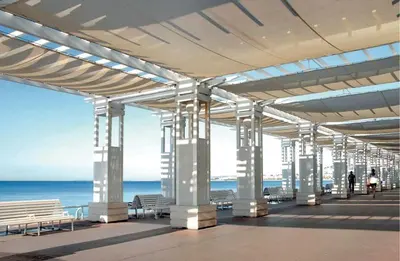 a building with benches and the ocean in the background at Appartement Les Plages in Nice