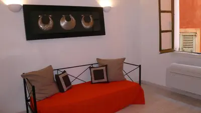 a bedroom with a red bed with two pictures on it at Appartements Vieux Nice / Marché aux fleurs in Nice