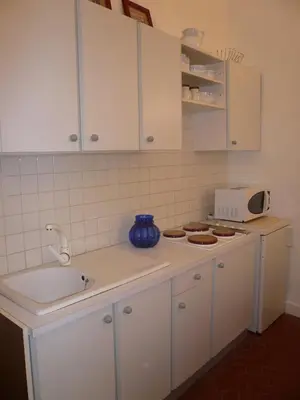a kitchen with white cabinets and a sink and a microwave at Appartements Vieux Nice / Marché aux fleurs in Nice