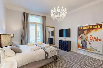 a bedroom with a large bed and a chandelier at Silver Suite Five Stars Holiday House in Nice