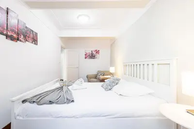 a white bedroom with a white bed and a sink at Large 3 Bdr Old Town - AC in Nice