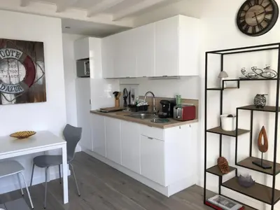 a kitchen with white cabinets and a table and a clock at Villa le Nid in Nice