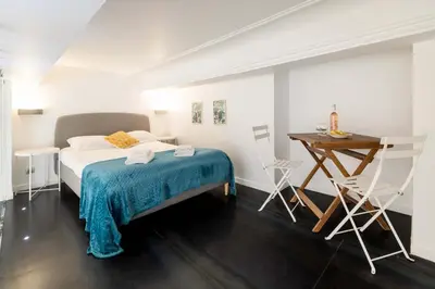 a bedroom with a bed and a table and chairs at Maison Bianchi - Duplex old town in Nice