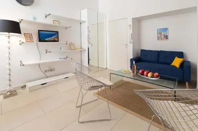a living room with a blue couch and a glass table at Maison Bianchi - Duplex old town in Nice
