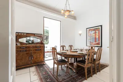 a dining room with a table and chairs and a mirror at Stylish Art Deco villa near the sea 4 Bdrs Pool and garage in Nice