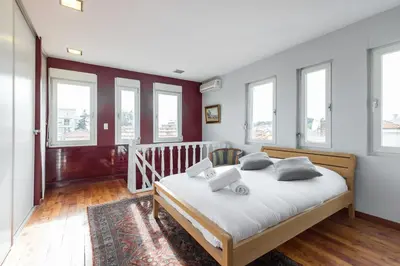 a bedroom with a bed with white sheets and windows at Stylish Art Deco villa near the sea 4 Bdrs Pool and garage in Nice