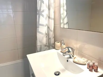 a white bathroom with a sink and a mirror at Super studio in the heart of Nice! in Nice