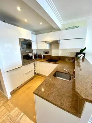 a kitchen with white cabinets and a sink at Le Panomagique in Villefranche-sur-Mer
