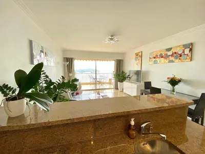 a kitchen with a sink and a living room at Le Panomagique in Villefranche-sur-Mer