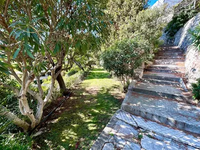 a stone path with trees and bushes on it at Le Panomagique in Villefranche-sur-Mer