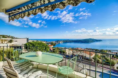 a balcony with a table and chairs and a view of the ocean at Luxurious Penthouse with panoramic view in Villefranche-sur-Mer