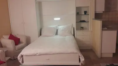 a small bedroom with a bed and a chair at Studio cosy à Villefranche sur mer in Villefranche-sur-Mer
