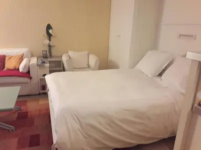a bedroom with a large white bed and a couch at Studio cosy à Villefranche sur mer in Villefranche-sur-Mer