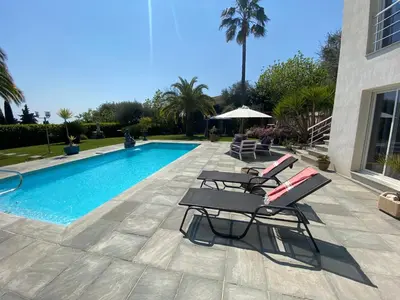 a swimming pool with two lounge chairs next to a house at Diamond Villa 5 Star - NICE in Nice