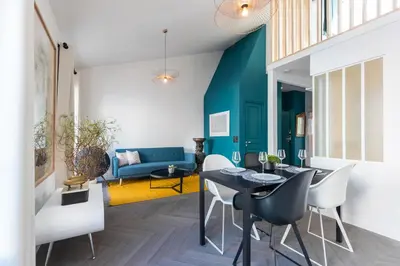 a living room with a table and chairs and a couch at L'Abeille - Boutique Apartments in Nice
