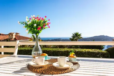 a table with cups and a vase with flowers on it at HENRIETTA AP4070 - avenue Soleil d'Or - Villefranche-sur-Mer in Villefranche-sur-Mer