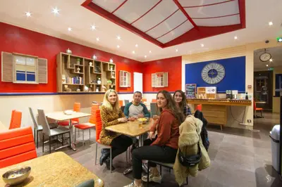 a group of women sitting at a table in a restaurant at Antares hostel in Nice