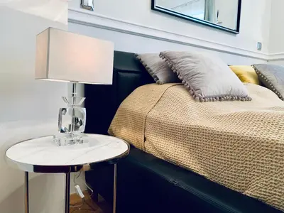 a lamp on a table next to a bed at Villa Bagatelle - Luxury apartment in Nice