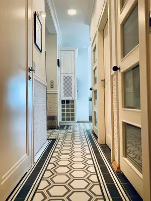 a hallway with a tile floor and doors at Villa Bagatelle - Luxury apartment in Nice