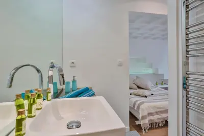 a white bathroom with a sink and a bed at MY CASA - LIBERTÉ - Spacious Apartment City Center w AC in Nice