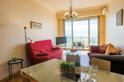 a living room with a red couch and a table at LE FLORIDE AP4156 Nice, by Riviera Holiday Homes in Nice