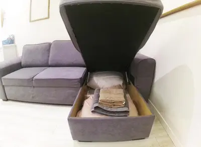 a box with clothes in it next to a couch at Apartment in the heart of Nice in Nice
