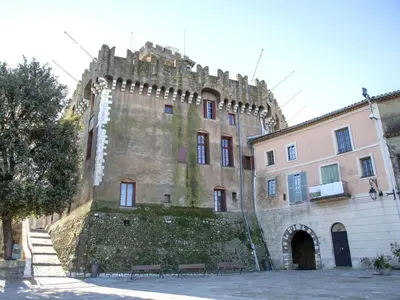 an old castle with a wall and benches in front of it at Apartment La Pinède-2 by Interhome in Le Puits