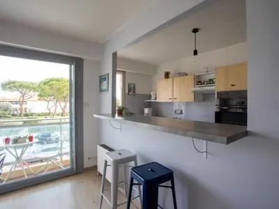 a kitchen and living room with a table and chairs at Apartment La Pinède-2 by Interhome in Le Puits