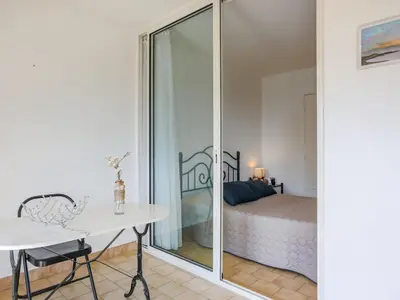 a living room with a blue couch and a kitchen at Apartment Domaine du Clairfontaine by Interhome in Nice