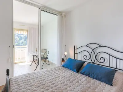 a kitchen with white cabinets and a white refrigerator at Apartment Domaine du Clairfontaine by Interhome in Nice