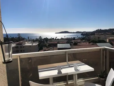 a balcony with a table and chairs and the ocean at **** Panoramic Top Roof in Beaulieu **** in Beaulieu-sur-Mer