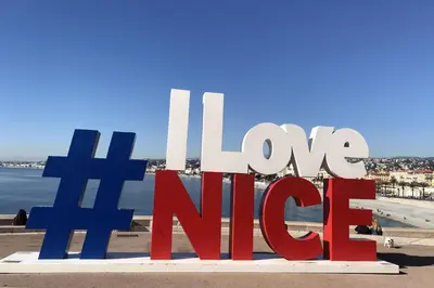 a sign that reads love nirvana on the beach at La Maioneta Carré d'Or in Nice