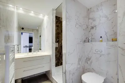 a white bathroom with a toilet and a mirror at La Maioneta Carré d'Or in Nice