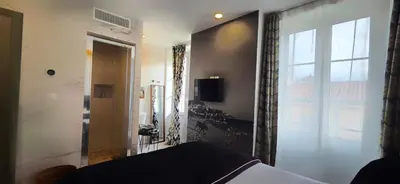a bedroom with a bed and a large window at Le Petit Trianon et le Charme des Suites in Nice