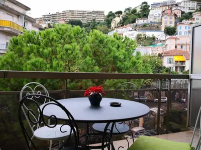 a table and chairs on a balcony with a view at Studio Nice colline avec parking privé in Nice