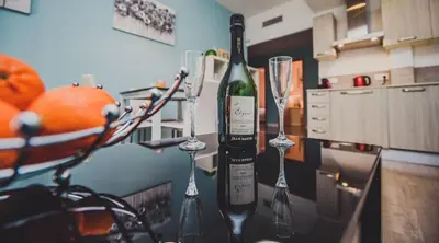 a bottle of wine and two wine glasses on a counter at AzurAppart 3room Nice Promenade in Nice
