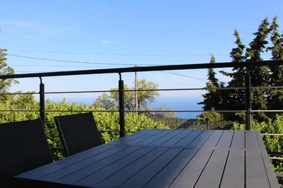 a wooden table on the balcony of a house at Les Bastides D'Hélène in Èze