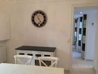 a clock on the wall above a table and two chairs at Les Bastides D'Hélène in Èze