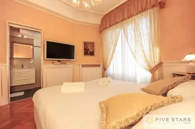 a bedroom with two beds and a tv on the wall at Le Majestic Promenade - Five Stars Holiday House in Nice
