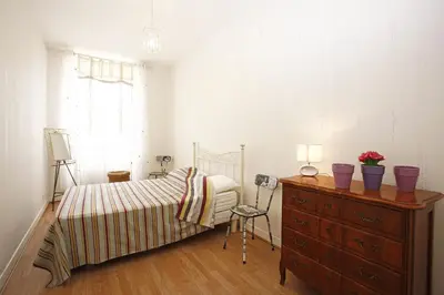 a bedroom with a bed and a dresser with flowers on it at AIGUE-MARINE - Superbe appartement Vue Mer 4 personnes au Port de Nice in Nice