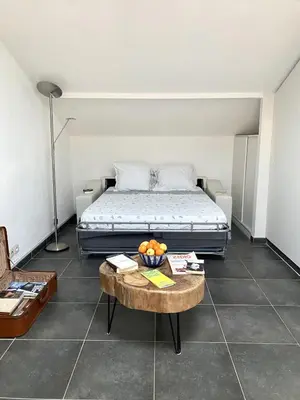 a bedroom with a bed and a table with a bowl of fruit at TOBIAS - Appartement Duplex 4 personnes Quartier Riquier Nice in Nice