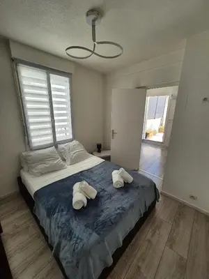 a bedroom with a bed with two towels on it at Plein centre Appartement climatisé et spacieux avec grande terrasse sur le toit à Nice in Nice