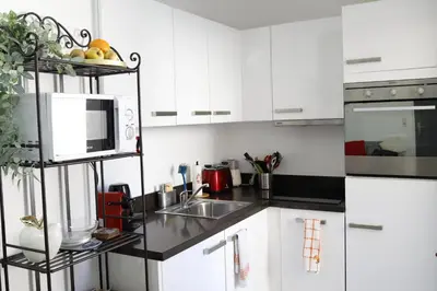 a white kitchen with a sink and a microwave at Luxueux 3 Pièces - Wilson in Nice