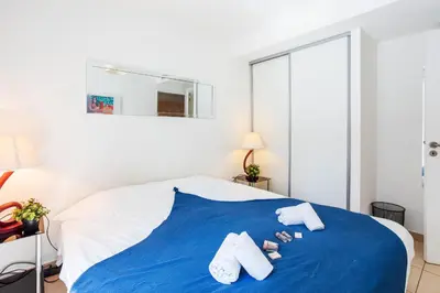 a bedroom with a blue bed with towels on it at VICTOR HUGO AP4159 Nice, by Riviera Holiday Homes in Nice