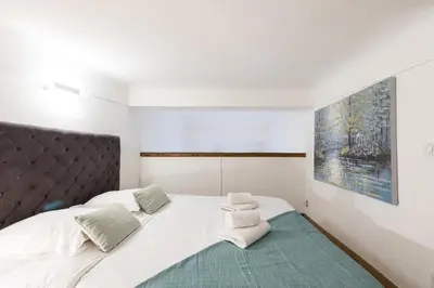 a bedroom with a large white bed with towels on it at Duplex in Rue de la Préfecture Old Town 2 Bdrs in Nice
