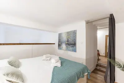 a white bedroom with a bed with towels on it at Duplex in Rue de la Préfecture Old Town 2 Bdrs in Nice