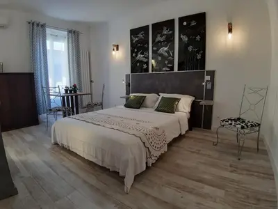 a bedroom with a large bed and a chair at Studio Lou Nidou, Nice Centre in Nice