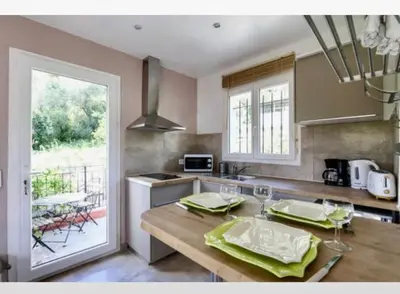 a kitchen with a table with green napkins on it at STUDIO pied village EZE - dans VILLA - Parking Gratuit in Èze