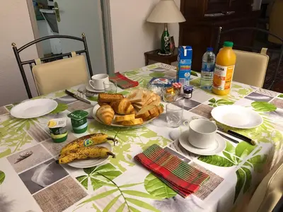 a table with a plate of food and bread on it at Villa C3 Arthur Rimbaub chambre d’hôte piscine proche mer plage 600m in Cagnes-sur-Mer